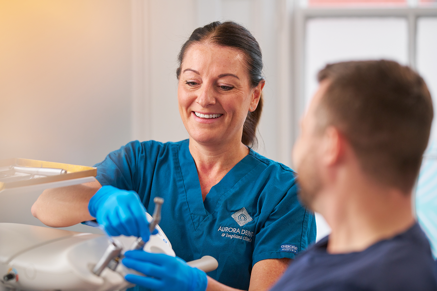 A photograph of a dental nurse interacting with patient