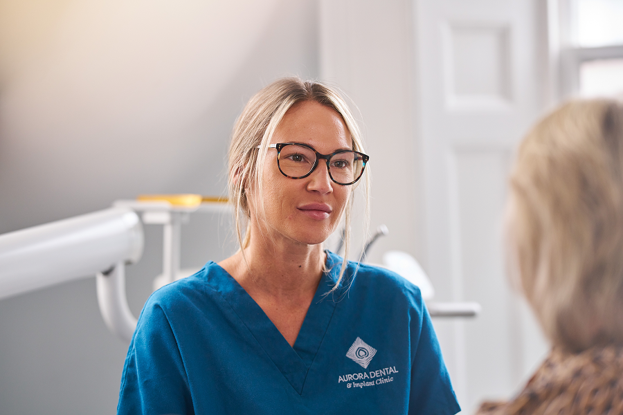 A close-up photograph of a dental nurse talking to patient